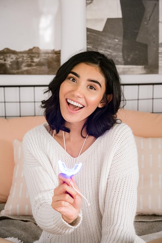 Photogenic woman smiling and holding her GLO technology warming LED mouthpiece