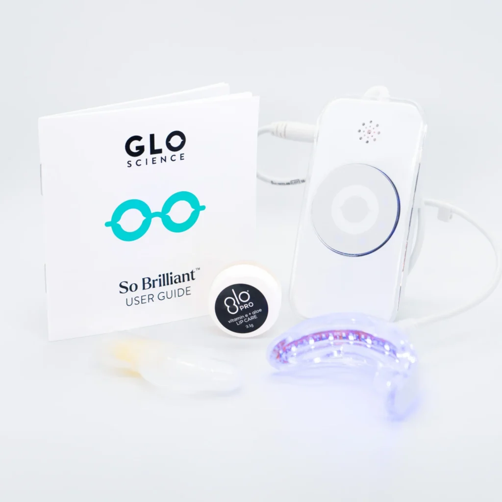 Sleek GLO Science GLO Pro whitening kit, with gel, glowing mouthpiece, and user guide on a white table